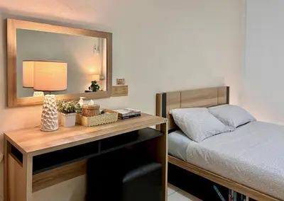 a bedroom with a bed and a desk with a mirror at INN Room in Bangkok