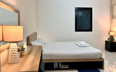 a bedroom with a bed and a wooden table at INN Room in Bangkok