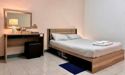 a bedroom with a bed and a desk with a mirror at INN Room in Bangkok