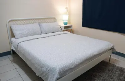 a bedroom with a white bed and a lamp on a table at INN Room in Bangkok