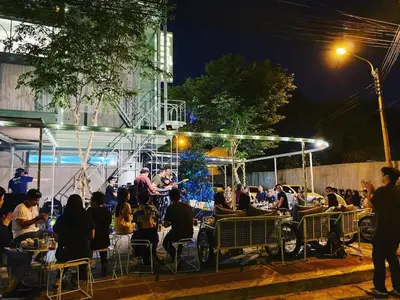 a group of people sitting at a restaurant at night at Samsen Street Hotel in Bangkok