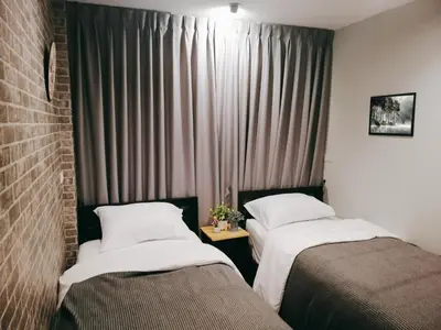 a hotel room with two beds and a window at White House Hostel in Bangkok