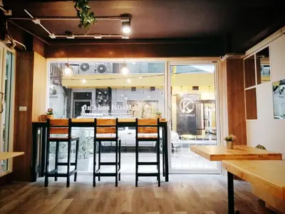 a bar in a restaurant with a table and chairs at White House Hostel in Bangkok
