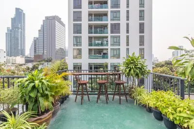 a balcony with a table and chairs on top of a building at Every Surawong in Bangkok