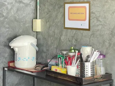 a table with a coffee maker and other items on it at The Quarter Wutthakat in Bang Khun Thian