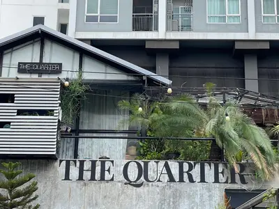 a building with a sign for the quartier at The Quarter Wutthakat in Bang Khun Thian