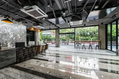 a lobby with tables and chairs and large windows at Bangkok City Link Hotel in Bangkok
