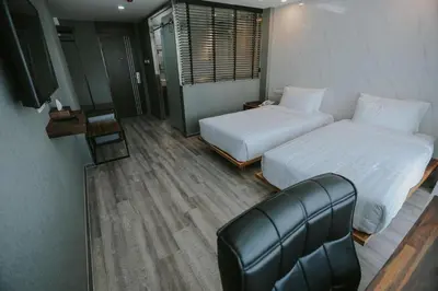 a hotel room with two beds and a couch at Bangkok City Link Hotel in Bangkok