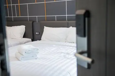 a bedroom with a bed with two towels on it at Hallton Hotel Bangkok in Bangkok