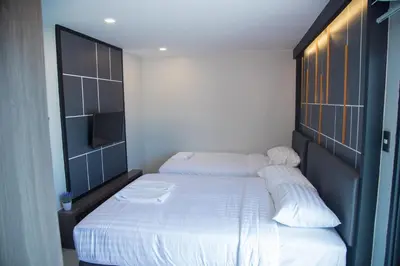 a bedroom with two beds with white sheets at Hallton Hotel Bangkok in Bangkok