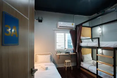 a room with two bunk beds and a desk at Private Stay Hostel in Bangkok