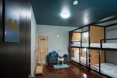 a small room with bunk beds and a chair at Private Stay Hostel in Bangkok