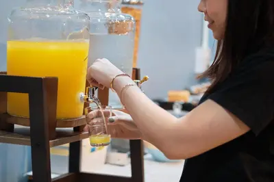 a woman is holding a glass of orange juice at Private Stay Hostel in Bangkok