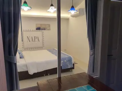 a mirror in a room with a bed in it at Napa Hostel Samrong Station in Samutprakarn