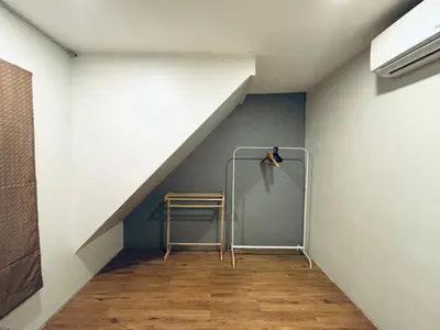 a room with a staircase with a ladder and a chair at Udomsuk Inn & Cafe - BTS Udomsuk in Bangkok