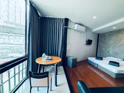 a small room with a table and a bed at Udomsuk Inn & Cafe - BTS Udomsuk in Bangkok