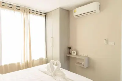 a bedroom with a bed with a towel on it at RQ Bangkok Sukhumvit 107 by Collection O in Samut Prakan