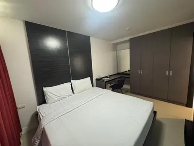a bedroom with a large white bed and a desk at Palette Bella B All Suites Bangkok Hotel in Bangkok