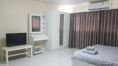 a bedroom with a bed and a television in it at ป๊อปปูล่า คอนโด อาคาร C4 impact เมืองทองธานี in Nonthaburi