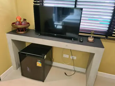 a flat screen tv sitting on top of a table at The Lantern Suites in Ban Song Hong