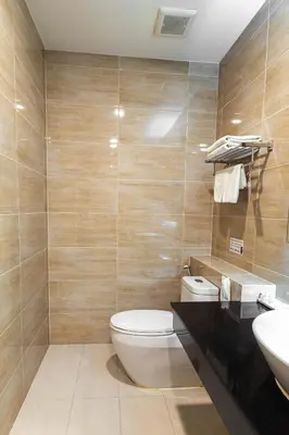a bathroom with a toilet and a sink at Leela Orchid Hotel in Bangkok