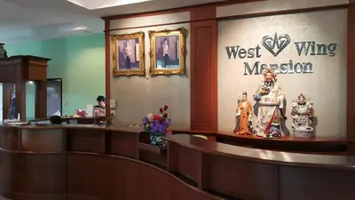 a waiting room with a west wing mission sign on the wall at West Wing Mansion in Bangkok