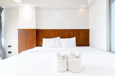 a bedroom with a white bed with two white shoes at A Sleep Bangkok Sathorn in Bangkok