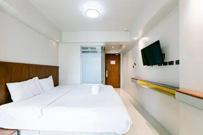 a bedroom with a bed and a tv on a wall at A Sleep Bangkok Sathorn in Bangkok