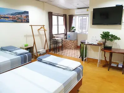 a room with two beds and a flat screen tv at 297 Nature Residence in Bangkok