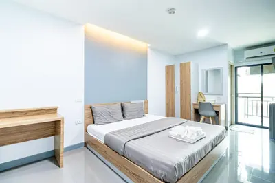 a bedroom with a bed and a desk in it at BeWish Residence Bangphlat in Bangkok