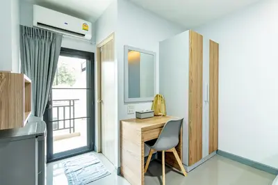 a room with a desk and a chair and a window at BeWish Residence Bangphlat in Bangkok