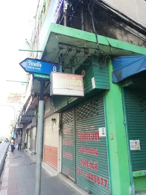 a street sign in front of a store at ICON HOSTEL in Bangkok