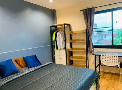 a bedroom with a bed and a desk and a window at ICON HOSTEL in Bangkok