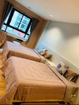 two beds in a room with a large window at ICON HOSTEL in Bangkok