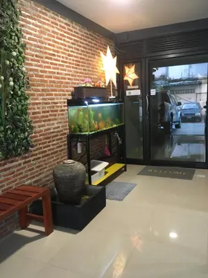 a room with a fish tank next to a brick wall at ICON HOSTEL in Bangkok