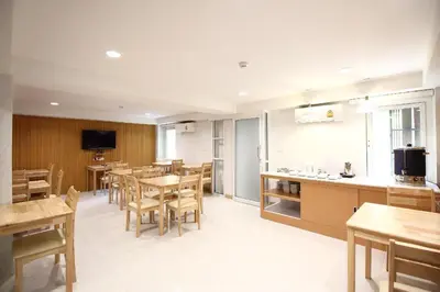 a restaurant with tables and chairs and a kitchen at Super OYO 483 Pannee Hotel Khaosan in Bangkok