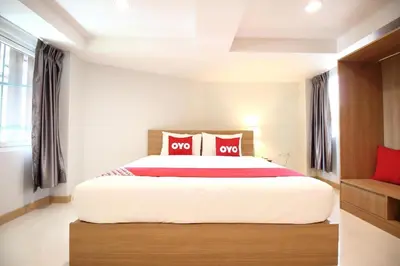 a bedroom with a large bed with red pillows at Super OYO 483 Pannee Hotel Khaosan in Bangkok
