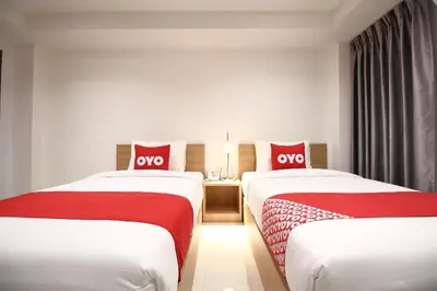 two beds in a hotel room with red and white sheets at Super OYO 483 Pannee Hotel Khaosan in Bangkok