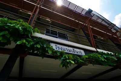 a sign on the side of a building with plants at N11Hotel in Bangkok