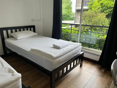 a bed in a room with a large window at N11Hotel in Bangkok