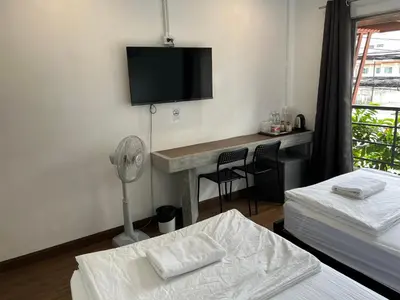 a hotel room with a desk and a tv on the wall at N11Hotel in Bangkok