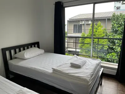 a bedroom with a bed and a large window at N11Hotel in Bangkok