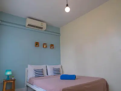 a bedroom with a bed with a pink blanket at Chan Cha La 99 Hostel in Bangkok