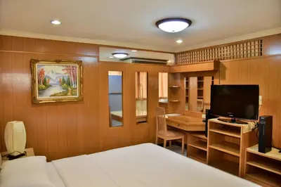 a bedroom with a bed and a desk and a television at The Kaze 34 Hotel and Serviced Residence in Bangkok