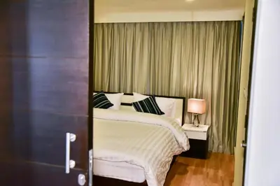 a bedroom with a bed and a lamp on a table at The Kaze 34 Hotel and Serviced Residence in Bangkok