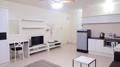 a white kitchen with a desk and a refrigerator at Popular Condo C2 in Nonthaburi