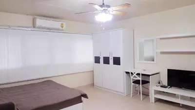 a bedroom with a bed and a desk and a ceiling fan at Popular Condo C2 in Nonthaburi