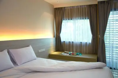 a bedroom with a large bed with a window at The Present Sathorn in Bangkok