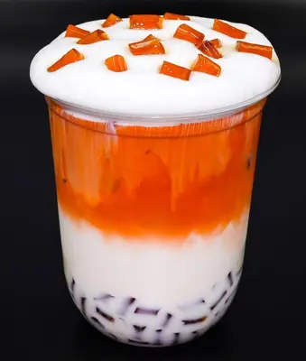 an orange and white drink with whipped cream and carrots on top at Siam Bright Suite in Bangkok