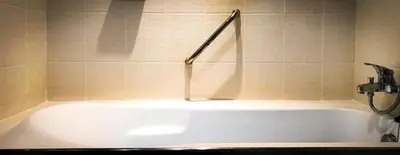 a bath tub in a bathroom with a shower at Siam Bright Suite in Bangkok